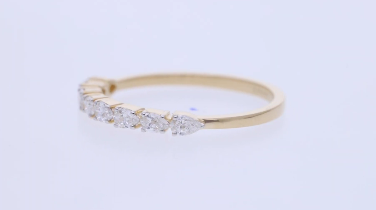 Gold ring with small diamonds on a light gray background